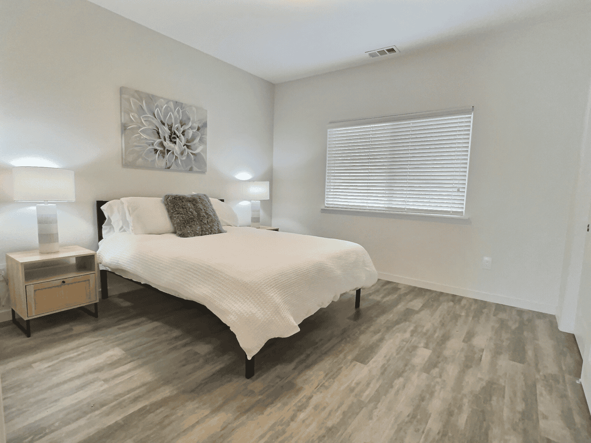 Bedroom 2 with queen bed, large windows, and closet space.