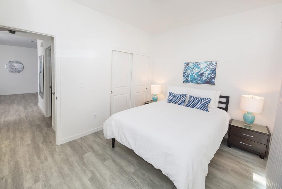 Bedroom 2 with sliding door to patio overlooking olive trees.